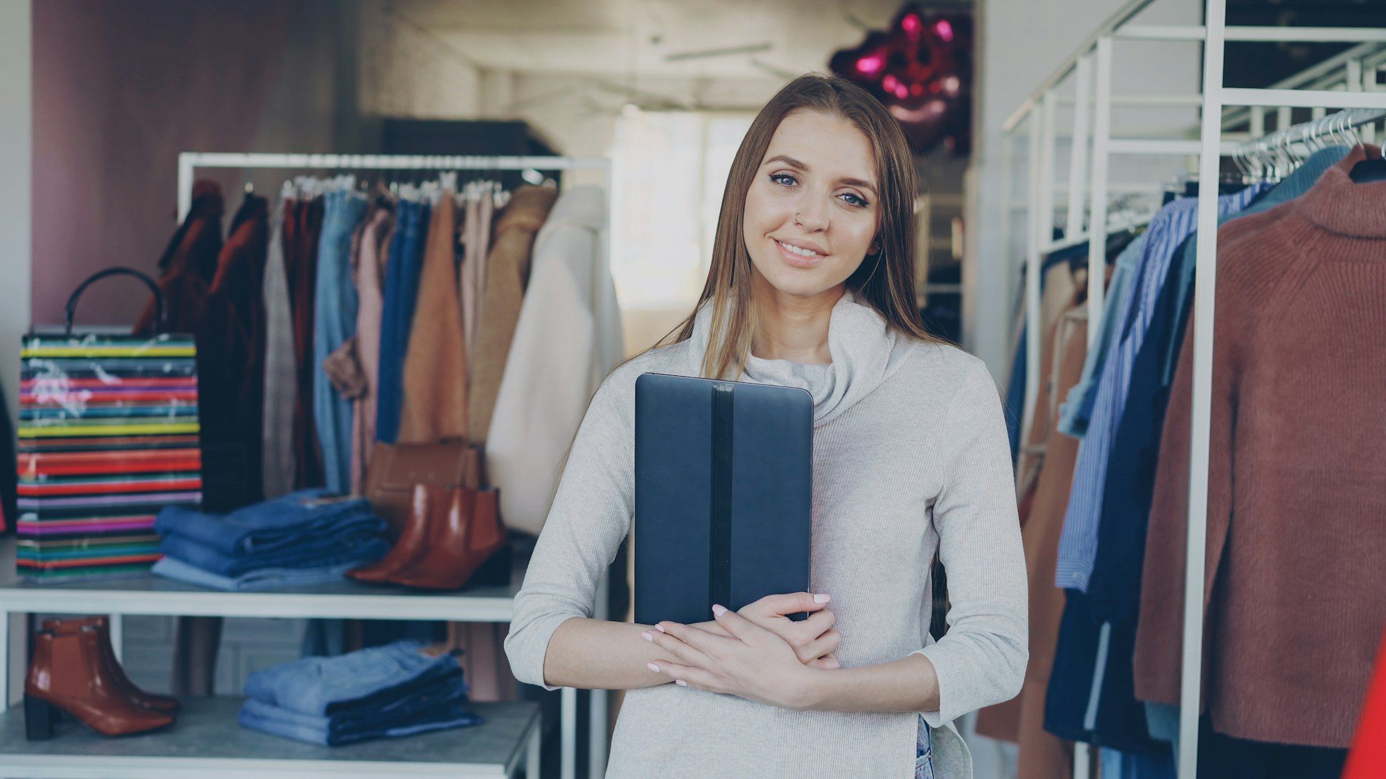 Une commerçante souriante dans sa boutique de vêtements